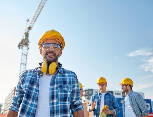Três homens com capacete de proteção em uma construção