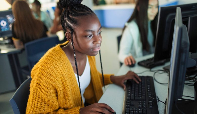 feira de estágio: mulher negra usando computador em busca de estágio