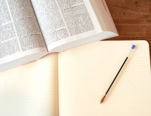 Um livro com um caderno e uma caneta