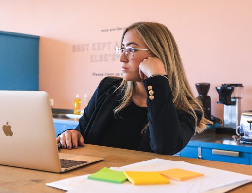 Uma mulher olhando para frente com um computador em sua frente