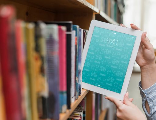 Pessoa pegando um kindle da estante de livros