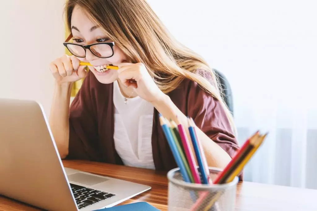 Menina estudando e mordendo um lápis